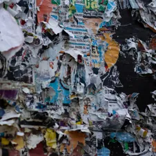 A torn and layered bulletin board filled with overlapping posters, symbolizing content clutter and digital disorganization.